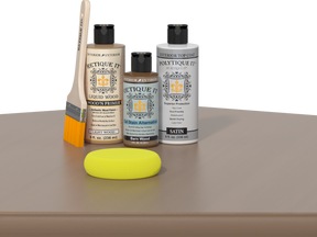 Retique It® Barn Wood kit with brush, Wood’n Primer, Barn Wood stain alternative, satin top coat, and yellow sponge on a reflective surface.