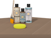 Retique It Barn Wood finishing kit with PolyTique It Matte top coat, Liquid Wood Wood'n Primer, Barn Wood Gel Stain Alternative, paintbrush, and yellow sponge displayed on a barn wood surface.