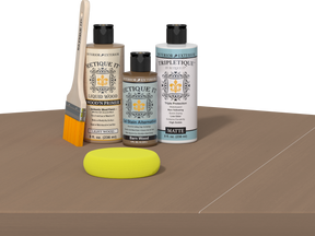 Retique It Barn Wood finishing kit with PolyTique It Matte top coat, Liquid Wood Wood'n Primer, Barn Wood Gel Stain Alternative, paintbrush, and yellow sponge displayed on a barn wood surface.