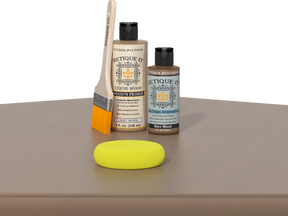 Retique It® Barn Wood Kit with Light Wood’n Primer, Barn Wood Gel Stain Alternative, paintbrush, and yellow sponge on a wood tabletop.