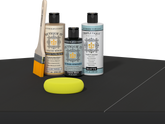 Retique It® Light Wood Wood’n Primer with Classic Black Gel Stain Alternative, matte topcoat, brush, and yellow sponge on a dark tabletop.