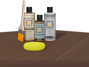 Retique It® Light Wood Wood’n Primer with Dark Oak Gel Stain Alternative, matte topcoat, brush, and yellow sponge on a dark tabletop.