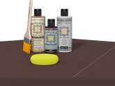 Retique It® Light Wood Wood’n Primer with Java Gel Stain Alternative, matte topcoat, brush, and yellow sponge on a dark tabletop.