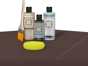 Retique It® Light Wood Wood’n Primer with Java Gel Stain Alternative, matte topcoat, brush, and yellow sponge on a dark tabletop.