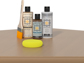 Retique It® Pecan Multipurpose Kit contents with Light Wood Liquid Wood primer, Pecan gel stain alternative, PolyTique It® satin exterior top coat, paintbrush, and yellow sponge displayed on a wood surface.