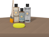 Retique It® Barn Wood Multipurpose Kit contents with Light Wood Liquid Wood primer, Barn Wood gel stain alternative, PolyTique It® matte exterior top coat, paintbrush, and yellow sponge displayed on a wood surface.
