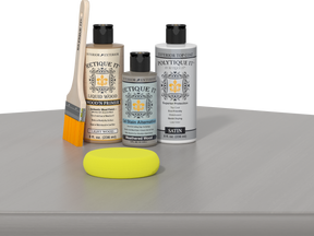 Retique It® Light Wood kit with brush, Weathered Wood stain alternative, and satin top coat on a reflective surface.
