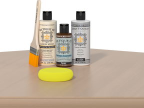 Retique It® White Oak kit with brush, Wood’n Primer, Pecan stain alternative, satin top coat, and yellow sponge on a wood surface.