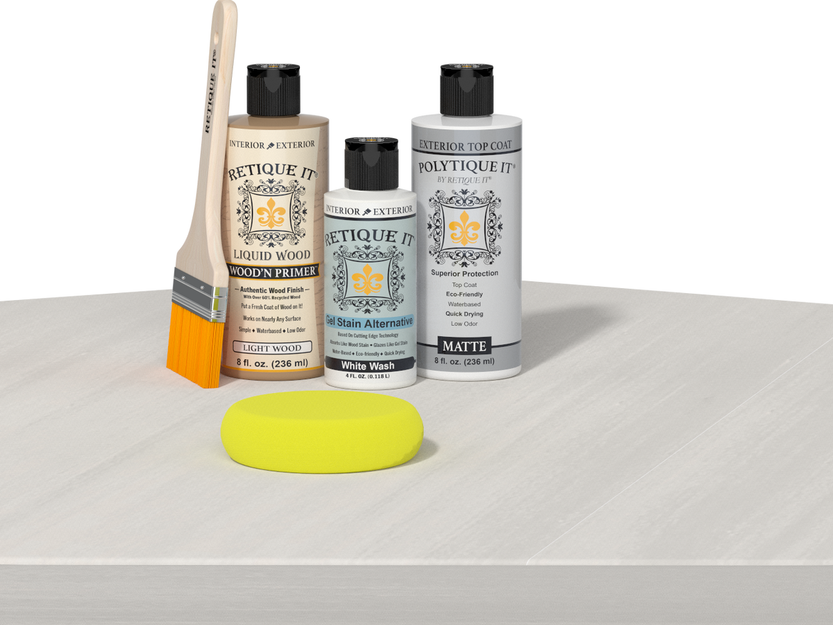 Retique It® Light Wood Wood’n Primer with White Wash Gel Stain Alternative, matte topcoat, brush, and yellow sponge on a white tabletop.
