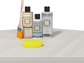 Retique It® Light Wood Wood’n Primer with White Wash Gel Stain Alternative, matte topcoat, brush, and yellow sponge on a white tabletop.