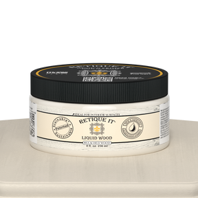 Retique It® Liquid Wood 8oz bleached interior paint jar on table, showcasing smooth, light-colored wood finish for home decor projects.