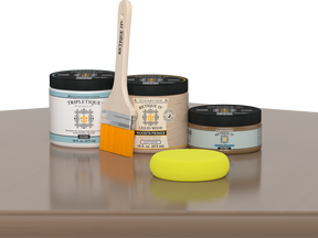Retique It Barn Wood Kit with Gloss Tripletique, Light Wood Wood'n Primer, Barn Wood Gel Stain Alternative, paintbrush, and yellow sponge on a tabletop.
