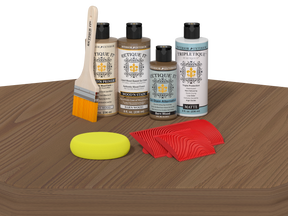 Set of wood care products including bottles, a brush, a sponge, and cloths on a wooden surface.