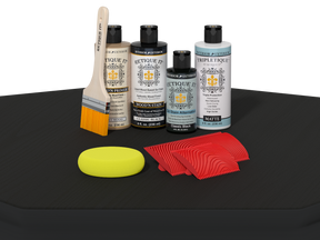 Set of car care products including bottles, a brush, and cloths on a black surface.