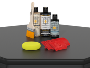 Set of paint-related products including bottles, a brush, and a sponge on a black surface with a white background.
