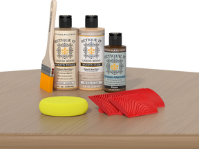 Retique It® Wood'n Finish Kit in Pickled Oak for tabletop staining, includes stain bottles and applicator tools, shown on a wooden surface.