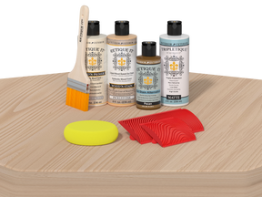 Set of wood care products including bottles, a brush, and sponges on a wooden surface.