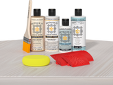 Retique It® White Wash Wood'n Kit with Light Wood primer, White Wash stain, White Wash gel stain alternative, Matte Tripletique® Top Coat, brush, red graining tool, and yellow sponge.