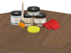Wooden surface with paint cans, a brush, and other tools on a white background