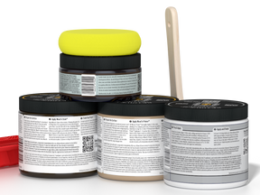 Four jars of paint with a yellow lid and a paintbrush on a white background