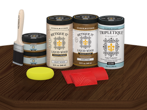 Retique It® Wood'n Finish Kit with four large dark oak stain bottles and a gloss finish on a tabletop.