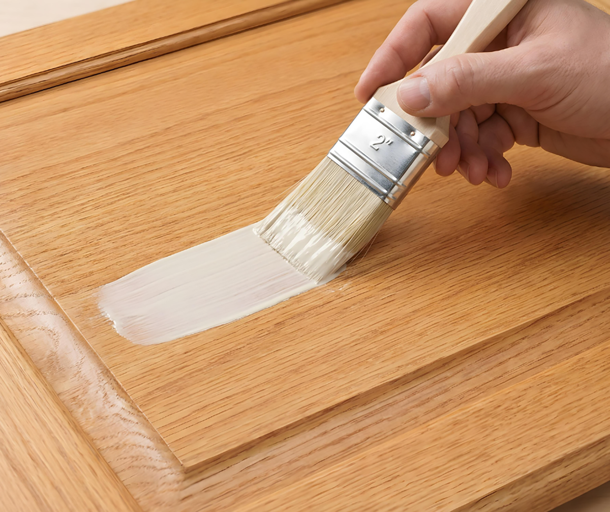 Retique It® Bleached Wood Kit primer being brushed onto a wood cabinet door.
