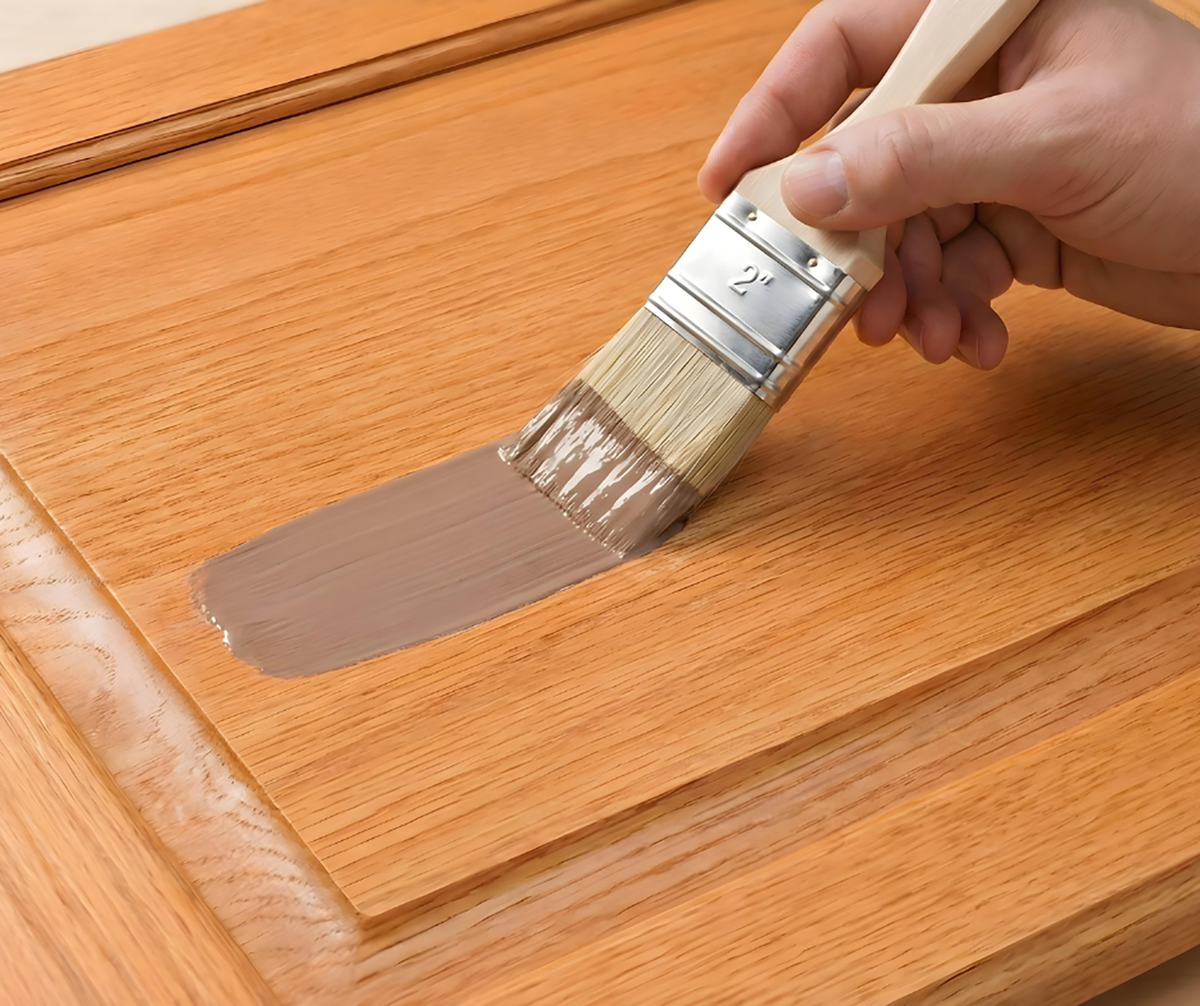 Retique It® Dark Wood Kit primer being brushed onto a wood cabinet door.