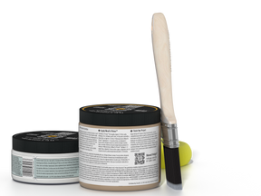 Two jars of a product with a brush on a white background