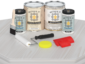 Paint cans and tools for wood staining on a white background