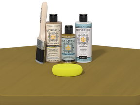 Set of art supplies including bottles, a brush, and a sponge on a brown surface.