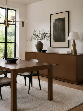 Contemporary dining room with a dark wood table, matching sideboard, neutral chairs, and brass-accented lighting.