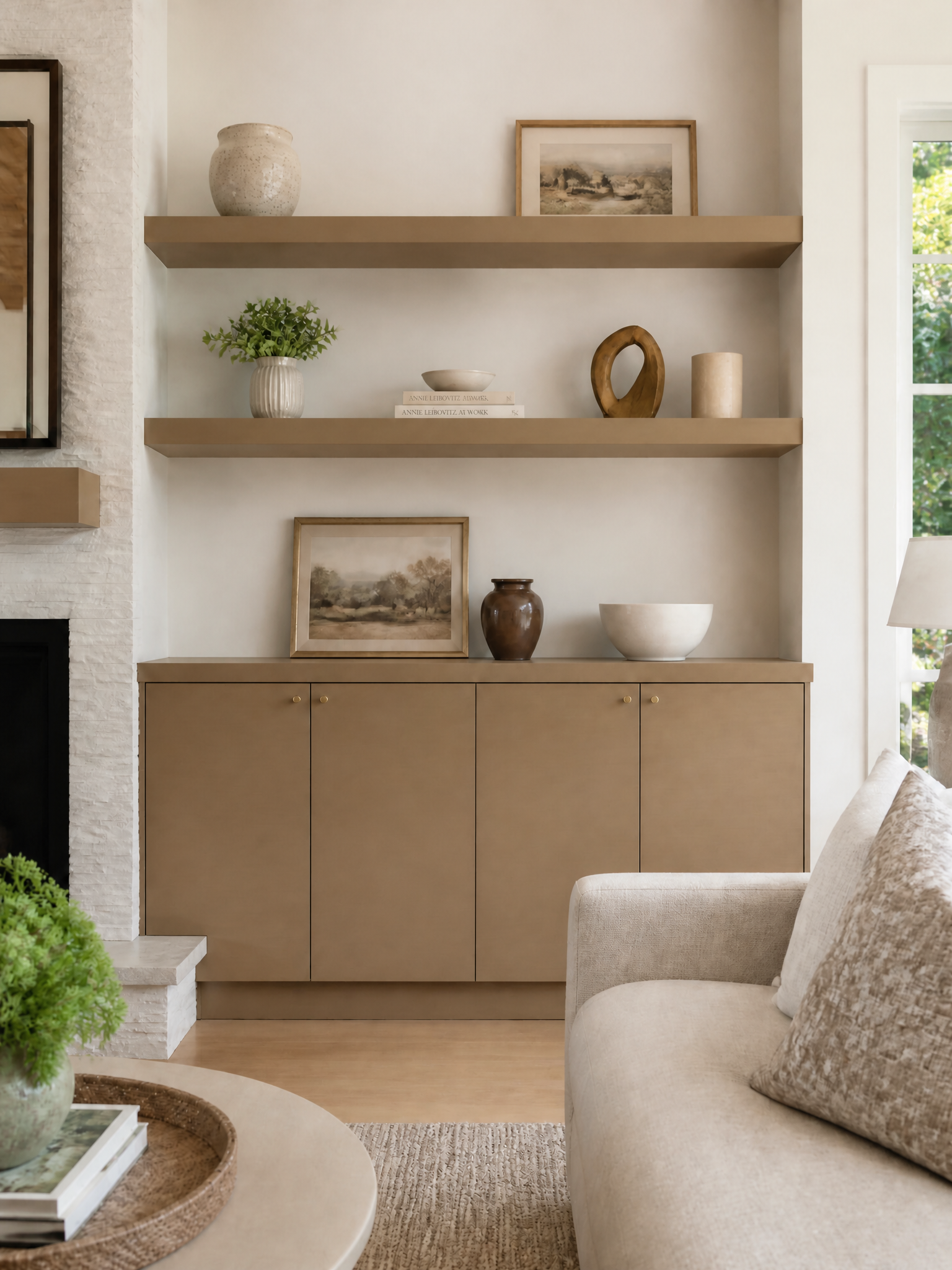 Built-in living room cabinet with shelves, neutral decor, and framed art.