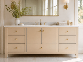 Neutral bathroom vanity with light wood cabinetry and gold accents.