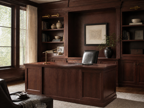 Traditional home office with a dark wood desk, leather chair, and built-in wood bookcases.