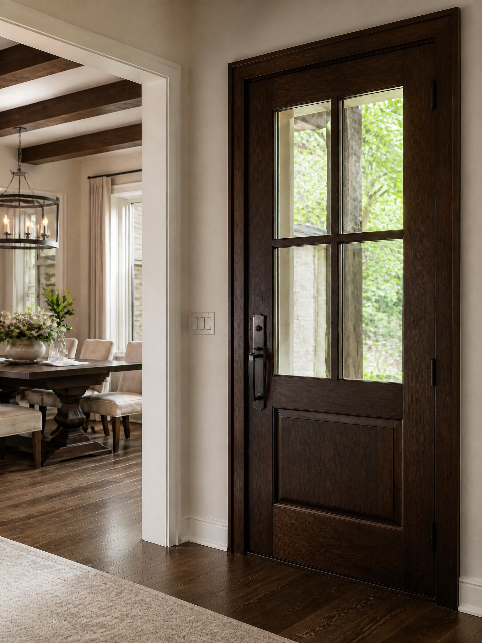 A dark brown wood entryway door with a six-pane top glass section, shown installed in a home entryway next to a dining room.