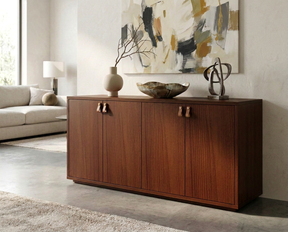 Dark walnut four-door sideboard with leather pulls, styled with sculptural decor beneath abstract artwork.